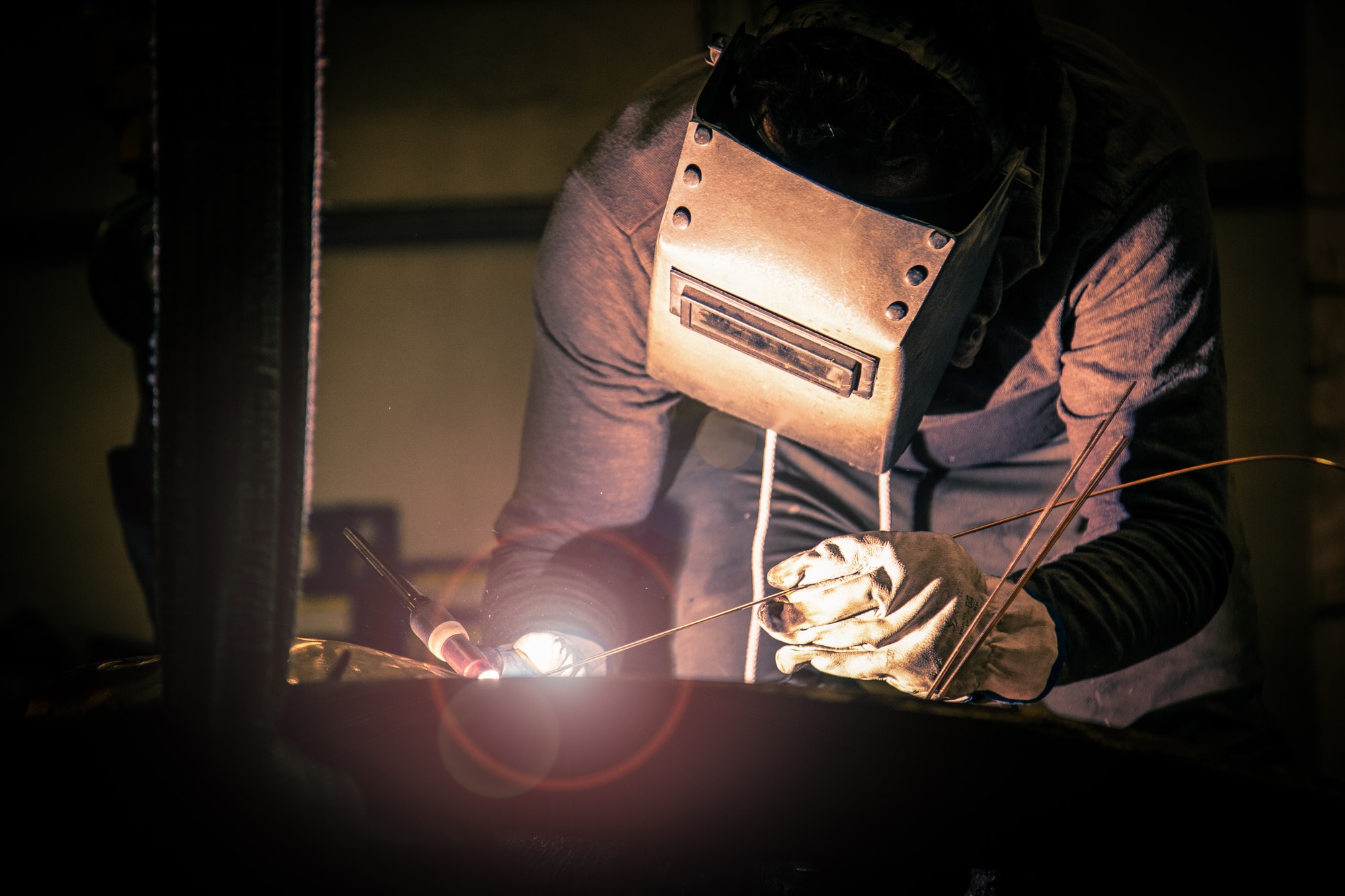 man-in-mask-welding-metal-ware-in-darkness.jpg