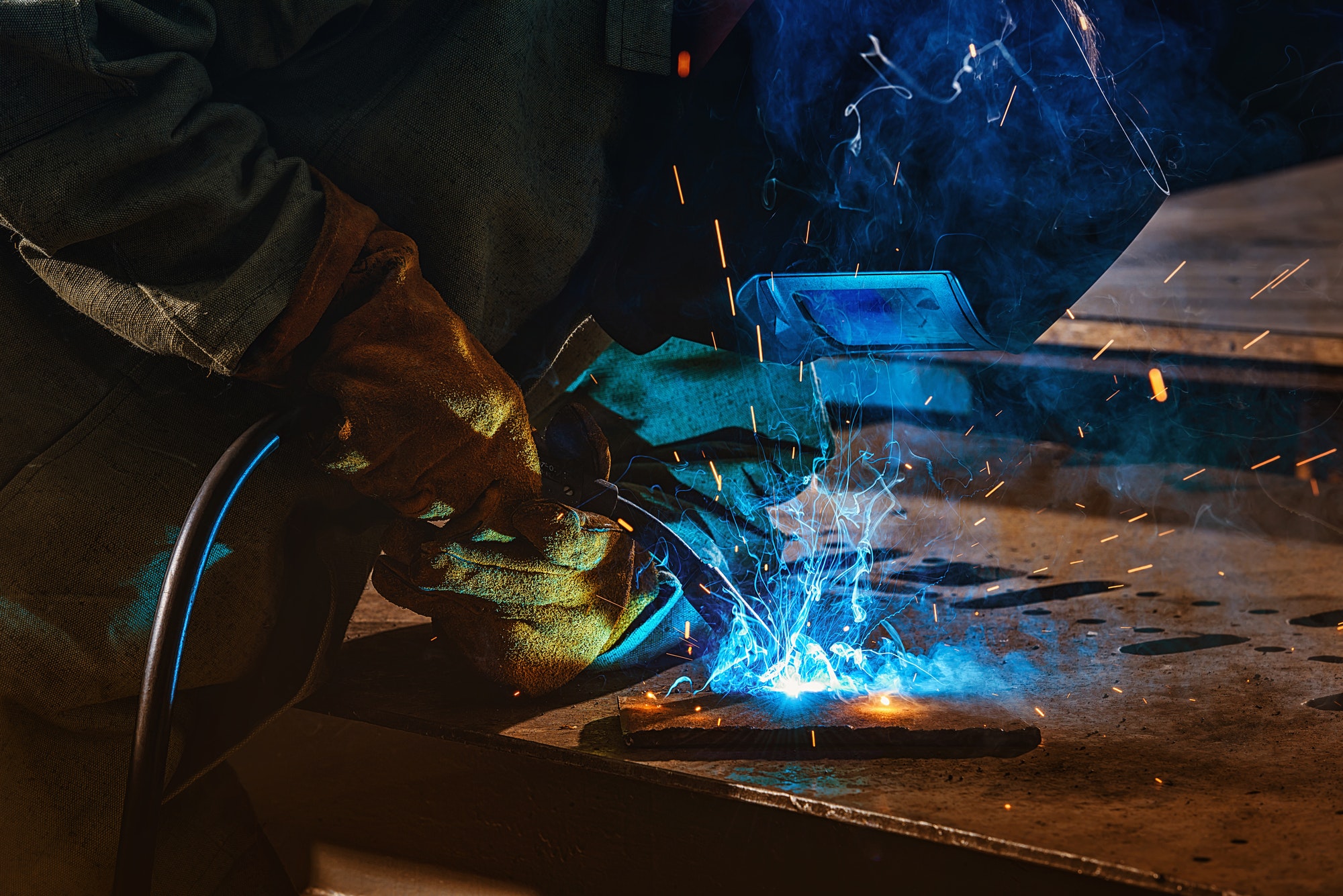 partial-view-of-welder-in-protection-mask-brazing-metal-at-factory.jpg